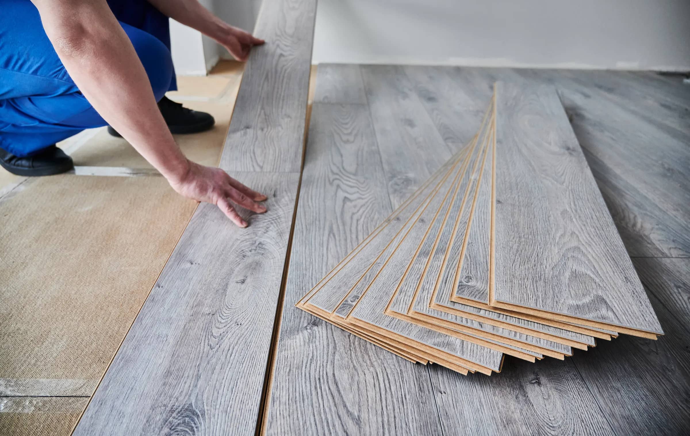 Grey laminate flooring being laid in a home